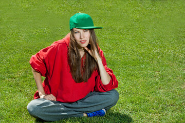 Wall Mural -  young woman lying on the grass wearing color youth clothes, space
