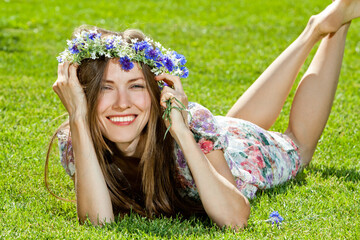 Wall Mural - young woman lying on the grass over green natural background