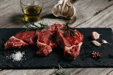 Poster - Closeup shot of raw beef slices with rosemary and garlic