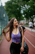 Young sporty woman listening music on running track. Beautiful woman in sportswear. 