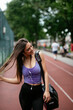 Young sporty woman listening music on running track. Beautiful woman in sportswear. 