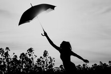 Unplugged Free Silhouette Woman Umbrella Up To Black White Sky. Nature Girl At Windy Rainy Day Has Adventure Wanderlust. Wonderful Scene Of Imagination Power And Departure To New Horizons In Youth