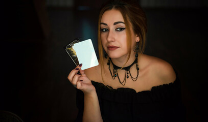   Woman fortune teller on a Tarot cards, Concept of predictions, magical rituals and wicca elements on a table 