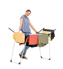 Wall Mural - Woman hanging clean clothes on dryer against white background