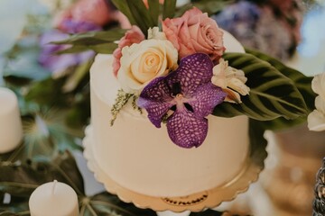 Poster - Closeup shot of a beautiful flower bouquet on a white cake for a luxurious event