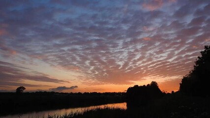 Wall Mural - time lapse movie of beautiful altocumulus clouds at sunset
