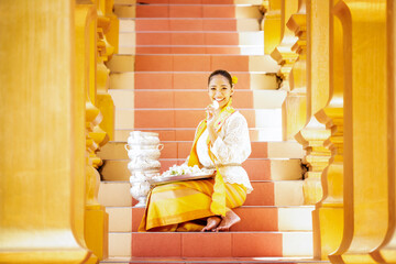 Women Burmese Buddhist faithful are walking barefoot around the Shwedagon Pagoda wearing a traditional and colorful Longyi (traditional Burmese clothes). Yangon, Myanmar.