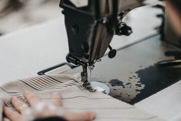 Poster - Closeup shot of a tailor sewing a cloth with sewing machine