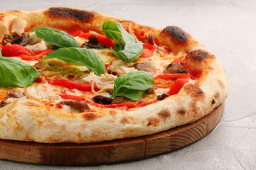 pizza with mushrooms, tomato and chicken closeup pizza with mushrooms and chicken on light concrete or stone table