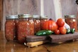 © Sherita - fresh tomatoes and jalapenos from a family farm vegetable garden with garlic and red onion for home canned spicy salsa in glass jars on a rustic background