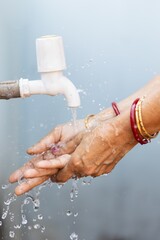 Poster - Female washing hands under the faucet - importance of washing hands during the COVID-19 pandemic