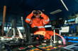 © Igor Kardasov - Filipino deck Officer on bridge of vessel or ship wearing coverall. He is looking through binoculars. COLREG navigaton watch at sea