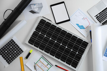 Flat lay composition with solar panel on white table. Alternative energy source