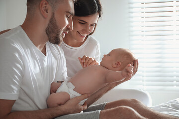 Happy couple with their newborn baby at home