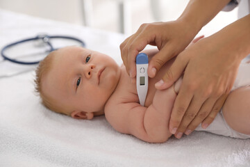 Poster - Doctor measuring temperature of little baby with digital thermometer indoors, closeup. Health care