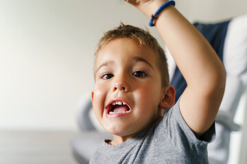 Front view close up portrait of small caucasian boy making faces at home - Little child 4 years old with odd facial expression and emotions