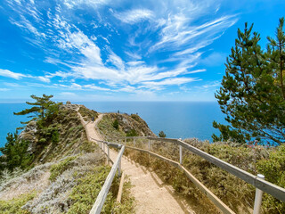 Seascape. The walkway leads to the observation deck. Summer, sunny day. Blue sky with white clouds. Muir woods beach overlook, California, USA