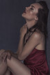© Ольга Ивлева - Hot young gir sits in black room in red sleep dress. Soft focus.