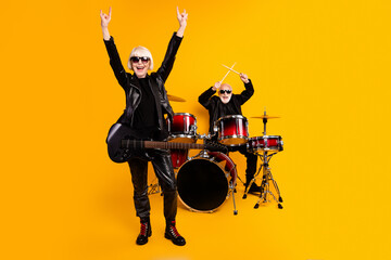 Sticker - Portrait of attractive elderly cheerful grey-haired couple performing hit genre having fun fame showing horn sign isolated over bright vivid shine vibrant yellow color background