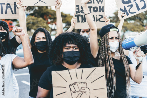 Plakat People from different culture and races protest on the street for equal rights - Demonstrators wearing face masks during black lives matter fight campaign - Focus on right girl face