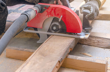 Sticker - Carpenter cuts wooden board with hand-held circular saw