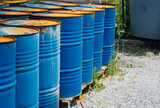 Fototapeta  - Big oil drums, blue. Chemical barrels in an open warehouse. Rusty barrels. Barrel for oil