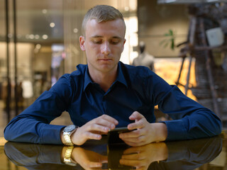 Wall Mural - Portrait of young blond businessman inside the shopping mall