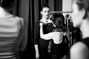 Plus size model get prepared to runway fashion show by make up artist. Black and white backstage concept