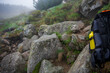plecak turystyczny i żółta metalowa butelka na wodę na tle zamglonego górskiego szlaku