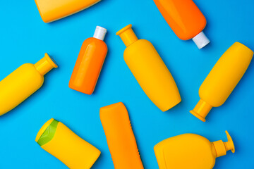 Wall Mural - Bottles of sunscreen cream on blue background