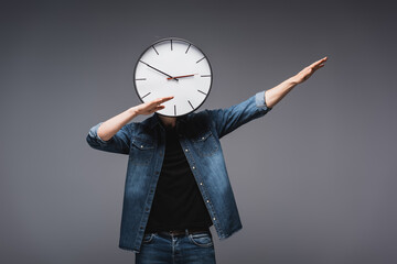 Wall Mural - Young man with clock near face gesturing on grey background, concept of time management
