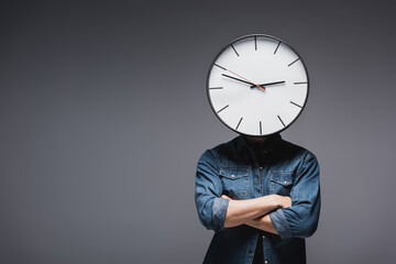 Wall Mural - Young man with clock on head and crossed arms on grey background, concept of time management