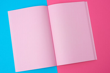 open notebook with blank pink pages on a blue background