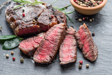 Wall Mural - Medium rare Ribeye steak with herbs on graphite board.