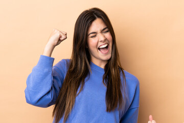 Teenager Brazilian girl over isolated background celebrating a victory