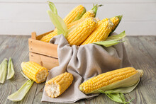 Box With Fresh Corn Cobs On Table