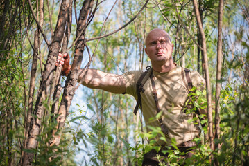 Wall Mural - A tourist is standing in the forest thicket.