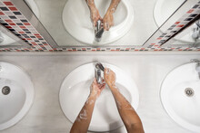 Top View Of Anonymous Male Washing Hands With Foam In Sink During Coronavirus Epidemic