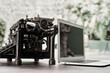 © Gabriel Trujillo/ADDICTIVE STOCK - Modern netbook and old fashioned typewriter placed on wooden table on terrace