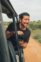 Happy Traveling Male With Professional Photo Camera Taking Photos Of Wildlife During Safari