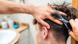 © Pol Sole/ADDICTIVE STOCK - Back view of unrecognizable male making haircut to guy using scissors against blurred interior of light bathroom at home