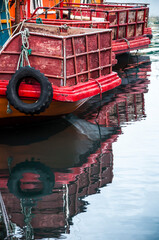 sterns of two fishing boats moored in the dock