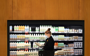 supermarket shopping, face mask and gloves,Woman choosing a dairy products at supermarket