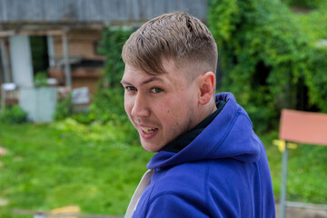 Close up portrait of young smiling handsome guy in a purple jacket