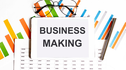 Poster - The tablet with text BUSINESS MAKING on business charts and pen