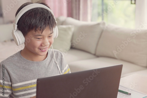 Preteen tween teen boy making facetime video calling with laptop at home, using online class meeting app, social istancing,homeschooling,learning remotely , new normal concept