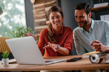 Colleagues in office. Businesswoman and businessman discussing work in office. Two friends in working together.