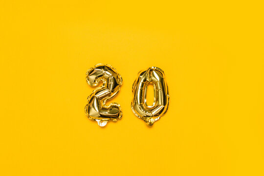 Gold glitter metal balls from numbers symbols. Ideal for discount sales. Isolated on a yellow background. Top view.