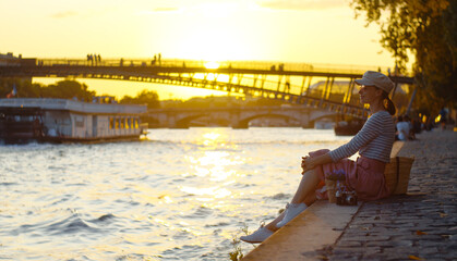 Wall Mural - Young girl by the river at sunset in Paris