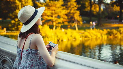 Wall Mural - Beautiful girl with a retro camera in Central Park